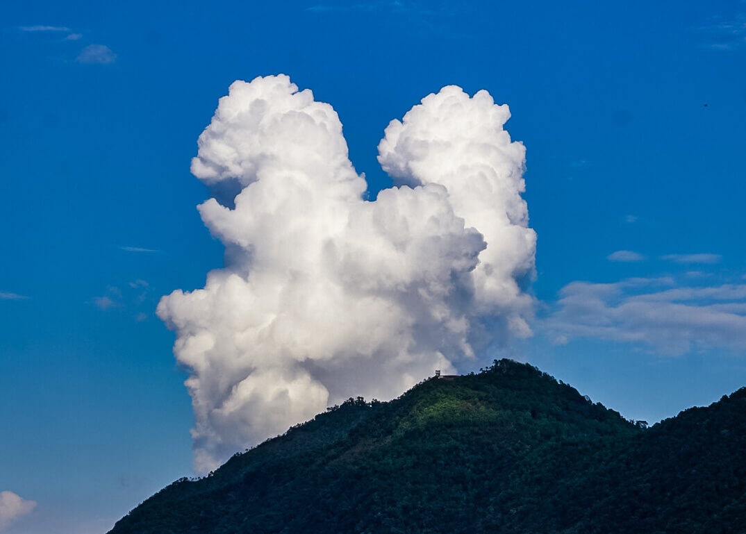 Cloud formation curling over a mountain ridge
